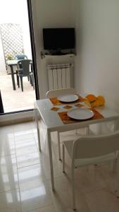 ポルト・チェザーレオにあるLa Vela Apartaments - Porto Cesareoの白いダイニングルーム(2皿、椅子付)