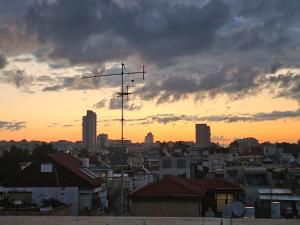 a view of a city at sunset with a weather vane at Lovely Apartment with shalter room in Tel Aviv