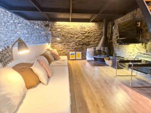 sala de estar con sofá y almohadas en Paller rústic de muntanya amb estil i acollidor by RURAL D'ÀNEU, en Aydí