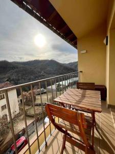 eine Veranda mit einem Holztisch und Stühlen auf dem Balkon in der Unterkunft Apartamento Les Orenetes in Espinelvas