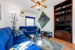 a living room with a blue couch and a ceiling fan at Seaside Retreat Casa Romana in Luz