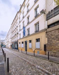 an empty street in front of a building at Hotel Aix Europe in Paris