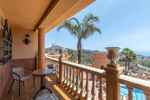 een balkon met uitzicht op de oceaan en palmbomen bij Castillo AlMálaga in Málaga