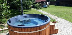 una gran bañera de hidromasaje de madera en un patio en Cabana Poiana Galdei en Poiana Galdei