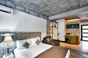 una camera con un letto bianco e una sedia di Balissimo Apartment by Hombali a Seminyak