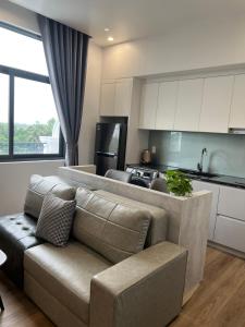 a living room with a couch and a kitchen at MinA Apartment - Vinhome Marina Hải Phòng in Hai Phong
