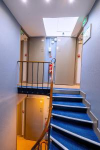 a staircase in a hallway with blue stairs in a building at Hotel Aix Europe in Paris