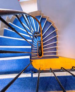 a spiral staircase in a building with blue steps at Hotel Aix Europe in Paris