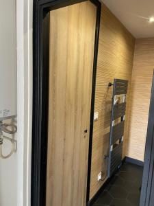 ein Bad mit einer Holztür in einem Zimmer in der Unterkunft Appartement joli et spacieux in Vitry-le-François