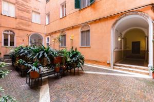 einen Innenhof mit Topfpflanzen in einem Gebäude in der Unterkunft New Suite Barberini Area in Rom