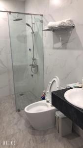 a bathroom with a shower and a toilet and a sink at MinA Apartment - Vinhome Marina Hải Phòng in Hai Phong