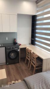 a kitchen with a washing machine and a table with chairs at MinA Apartment - Vinhome Marina Hải Phòng in Hai Phong