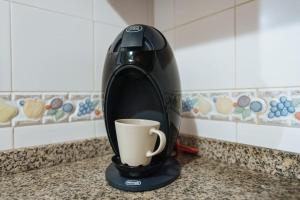 una cafetera sentada en un mostrador con una taza de café en Acogedor y central, en Sevilla