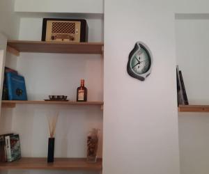 a clock on a wall next to a shelf at Apartment near Acropolis in Athens
