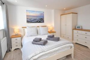 1 dormitorio con 1 cama con 2 toallas en Dexters Den - Sea views, yards from Beach, en Amble