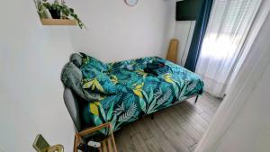 ein Bett in einem Zimmer mit einer Decke darauf in der Unterkunft Charmant 2p, piscine, clim, à 5 min de la plage in Vallauris