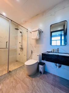 a bathroom with a toilet and a shower and a sink at MinA Apartment - Vinhome Marina Hải Phòng in Hai Phong