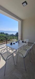 a white table and chairs on a balcony at Mariosa 2 in Vrbnik