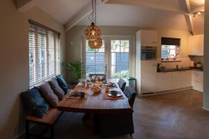 a living room with a table and a couch at Ruim vakantiehuis met mooie tuin op de Veluwe in Putten