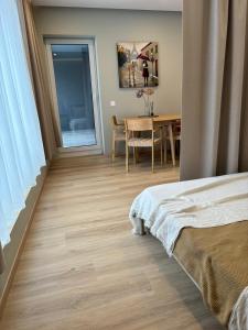 a bedroom with a bed and a table and a dining room at Charming Apartment In Zeimena's Street in Kaunas
