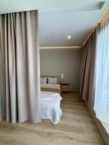 1 dormitorio con 1 cama y una ventana con cortinas en Charming Apartment In Zeimena's Street en Kaunas