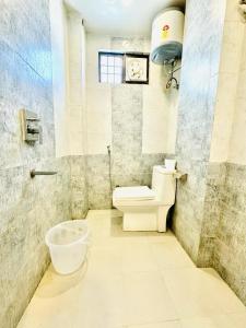 a bathroom with a toilet and a bucket in it at Galaxyy The Hotel Near Delhi Airport in New Delhi