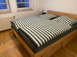 two beds with black and white striped sheets on them at Ferienwohnung am Obertor in Pfullendorf