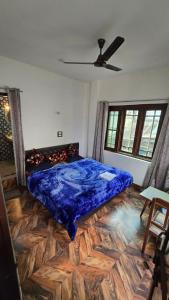 - une chambre avec un lit et une couverture bleue au sol dans l'établissement New Hotel Meghdoot, à Srinagar
