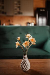a vase with white flowers sitting on a table at Domek przy szlaku in Rabka-Zdroj