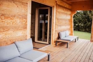 a porch of a log cabin with two chairs and a couch at Domek przy szlaku in Rabka-Zdroj