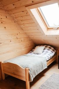 a bed in a wooden room with a window at Domek przy szlaku in Rabka-Zdroj