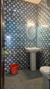 La salle de bains est pourvue d'un lavabo et de toilettes. dans l'établissement New Hotel Meghdoot, à Srinagar
