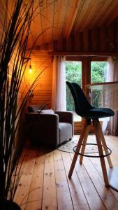 ein Wohnzimmer mit einem Stuhl und einem Sofa in der Unterkunft Sfeervol houten huis I Bosrijk Veluwe in Putten