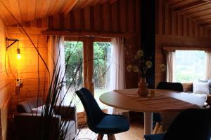 ein Esszimmer mit einem Tisch, Stühlen und einem Fenster in der Unterkunft Sfeervol houten huis I Bosrijk Veluwe in Putten