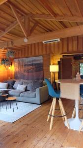 ein Wohnzimmer mit einem Sofa und einem Tisch in der Unterkunft Sfeervol houten huis I Bosrijk Veluwe in Putten