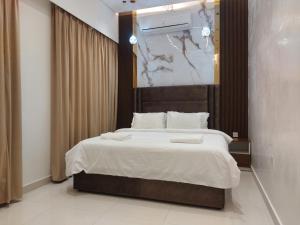 Mabahj Garnatha Hotel Apartments في صحار: غرفة نوم بسرير كبير مع شراشف بيضاء