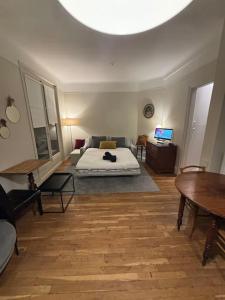 um quarto com uma cama e uma sala de estar com uma mesa em Élégance Parisienne pour 4 personnes em Paris