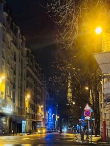 uma rua da cidade à noite com a Torre Eiffel em Élégance Parisienne pour 4 personnes em Paris
