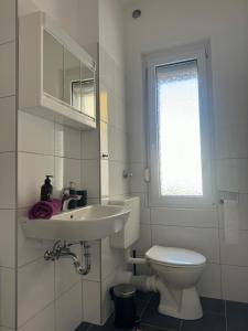 uma casa de banho branca com um lavatório e um WC em 82m2 - 4 Zimmer mitten in Hagen - huge open space em Hagen