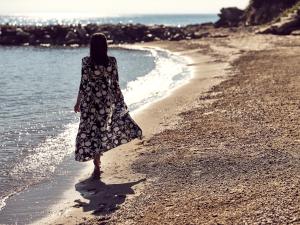 Kobieta spaceruje po plaży w obiekcie Lesante Blu, a member of The Leading Hotels of the World - Adults Only w mieście Tragaki