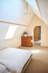 a bedroom with a bed and a dresser in a attic at Ferme de Franqueville in Sainte-Marie-du-Mont