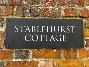 a sign on a brick wall with the words stritch outpost cottage at Stablehurst Cottage in West Hoathley