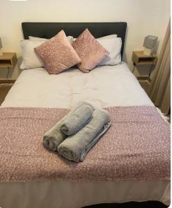 a bed with two towels and pillows on it at One bedroom ground floor flat central Chichester in Chichester