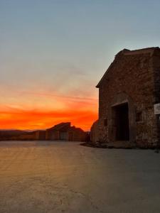 un antiguo edificio de piedra con una puesta de sol en el fondo en Apartamento Mezquita Caudiel, en Caudiel