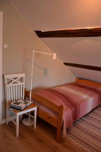 Lillstugan, södra Bergslagen في Surahammar: غرفة نوم بسرير وطاولة مع مصباح