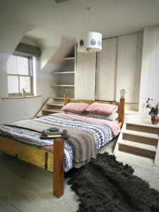 um quarto com uma cama de madeira e almofadas cor-de-rosa em Ballimackillichan Croft 