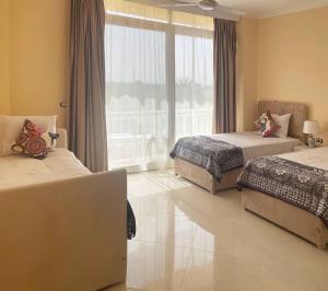 a bedroom with two beds and a large window at Karima House in Luxor