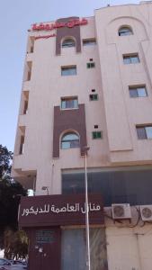 un edificio alto con un cartel delante en كيان العزيزية للشقق المخدومة - Kayan Al-Azizia Serviced Apartments en Yeda