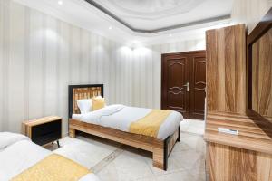 a bedroom with two beds and a tv in it at درب البحر in Jeddah