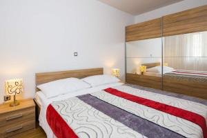 a bedroom with a large bed with a red and white blanket at Apartments Vista Bol in Bol